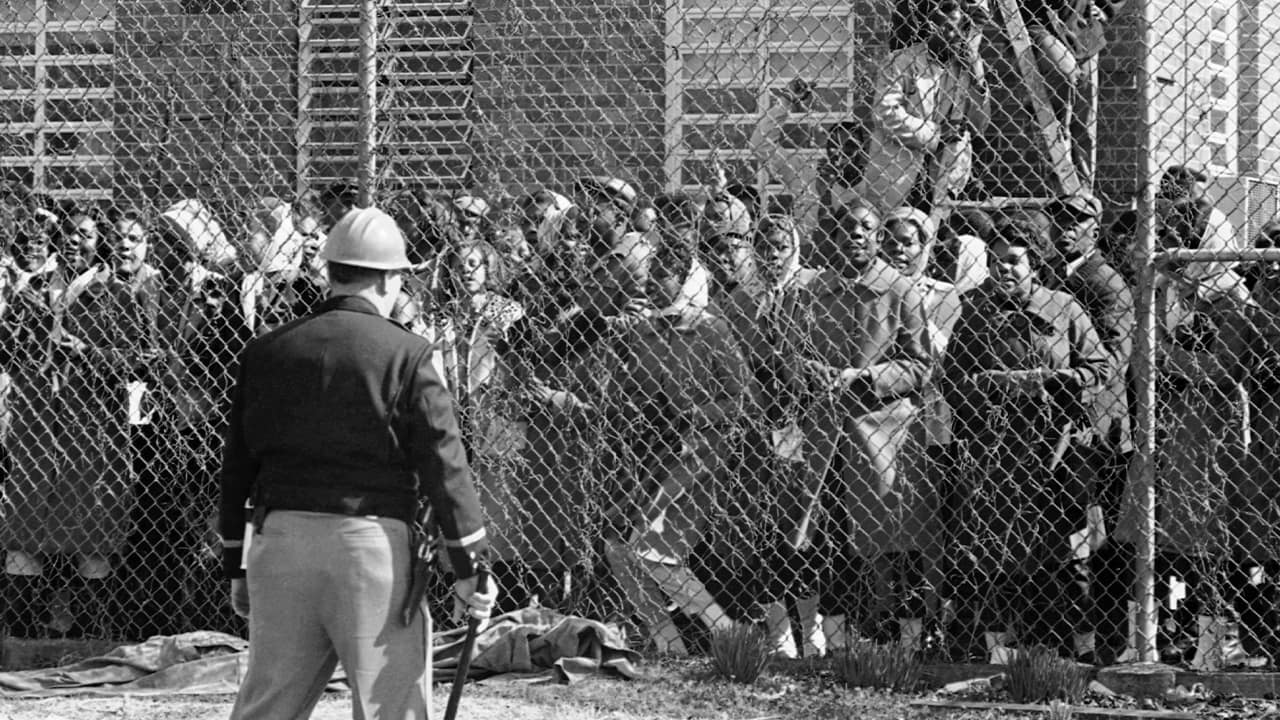 Photo of a policeman outside a fence surrounding the Perry County Jail in Marion, Ala. in 1965