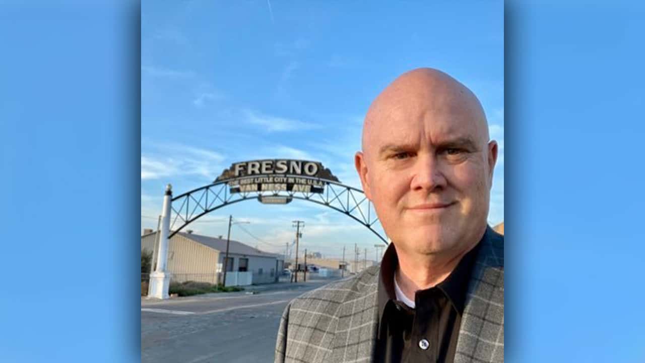 Image of Bob Nelson in front of the "Fresno" sign downtownRes