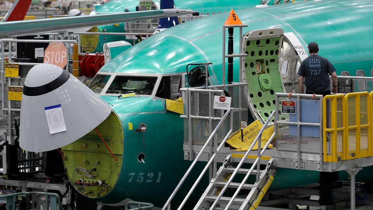 Photo of a working entering a Boeing 737 MAX 8 airplane 