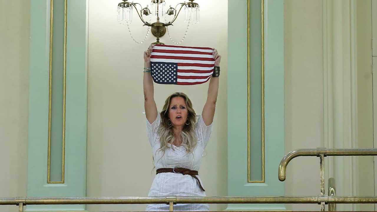 Photo of Tara Thornton holding an American flag upside down 