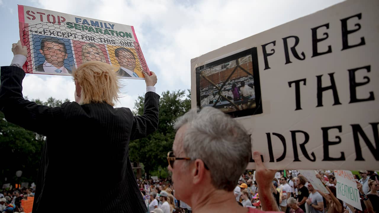 Photo of protestors holding up signs during a protest against detaining migrant children 