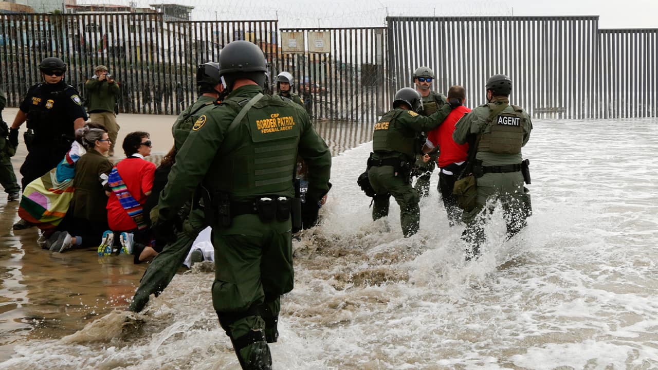 Photo of border patrol agents detaining a man near Tijuana 