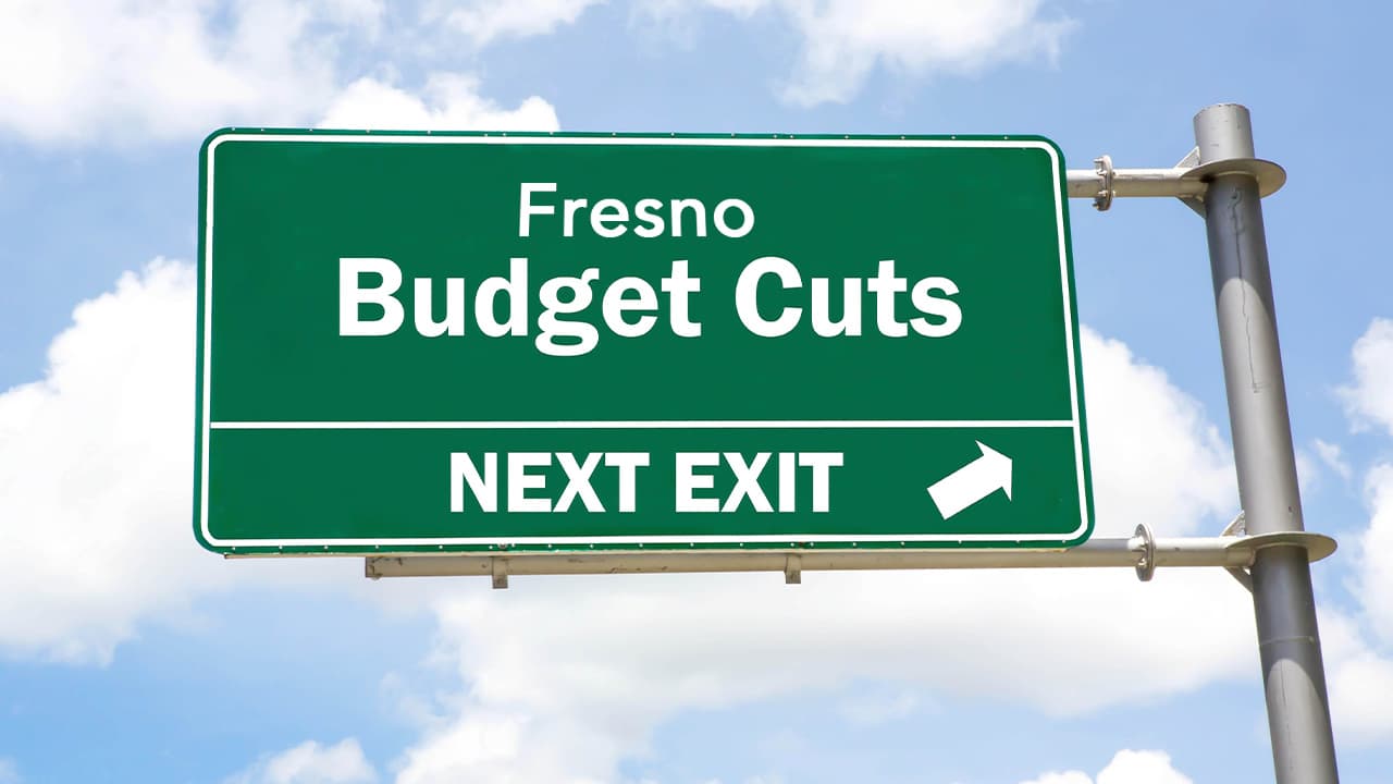A freeway exit sign that says Fresno Budget Cuts