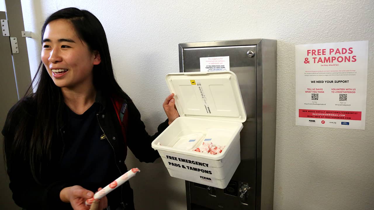 Photo of UC Davis student working to ensure placement of tampons and pads in UC Davis restrooms