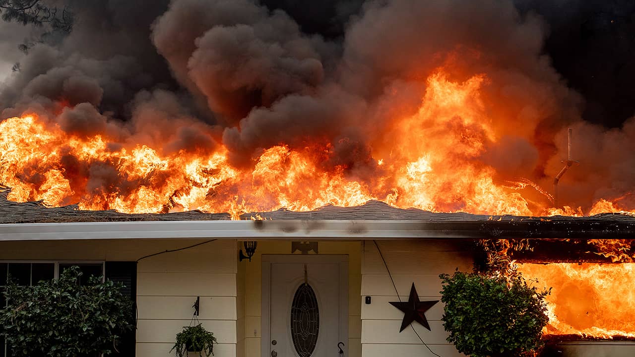 Photo of a home burning in Paradise, California.