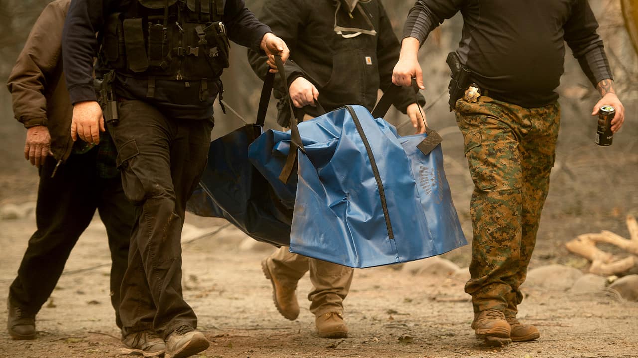 Photo of firefighters and deputies carrying a body of a Camp Fire victim