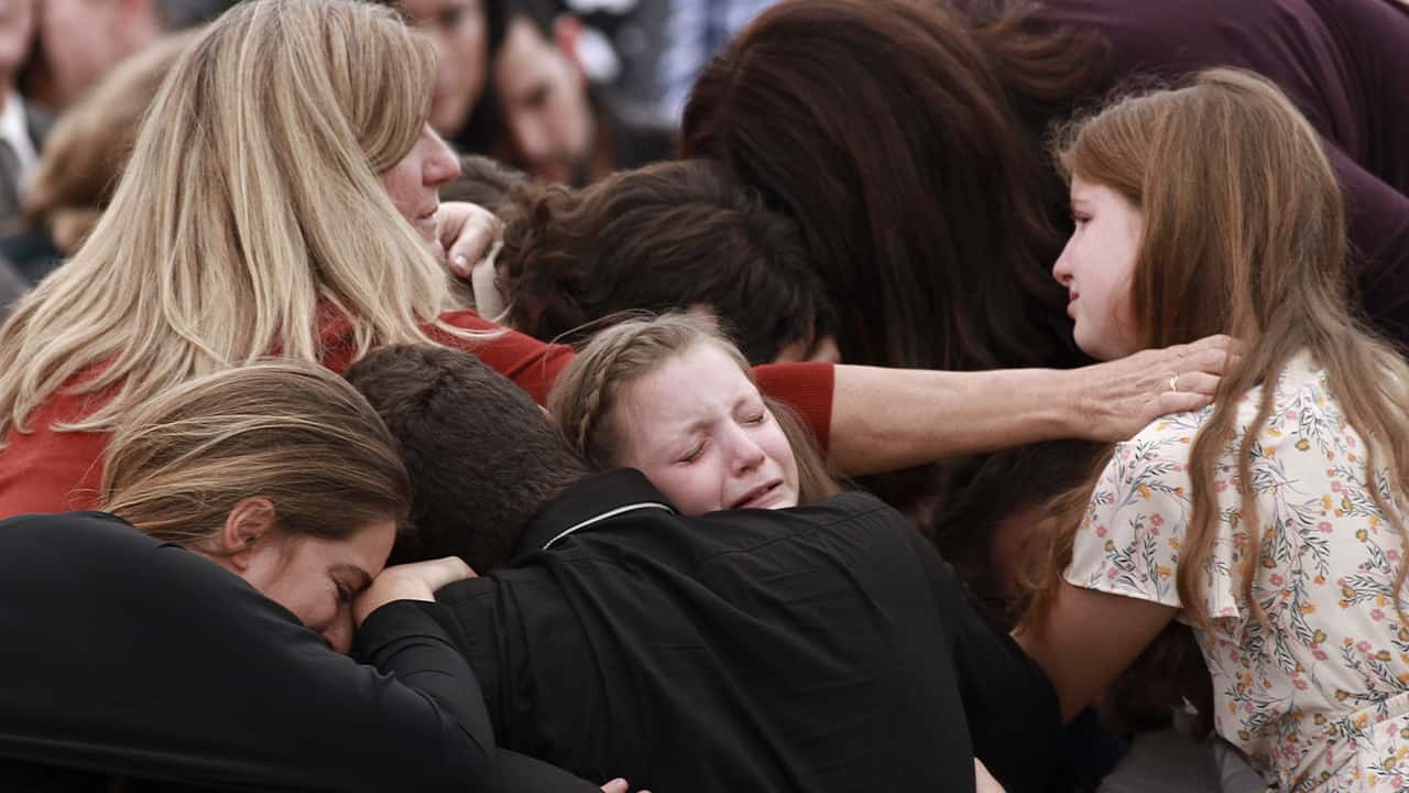 Photo of family and friends weeping at a funeral
