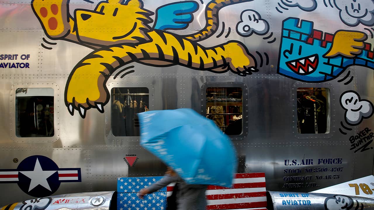 Photo of a woman walking by a painted bench in Beijing