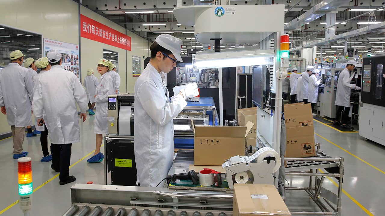 Photo of a staff member works on a mobile phone production line