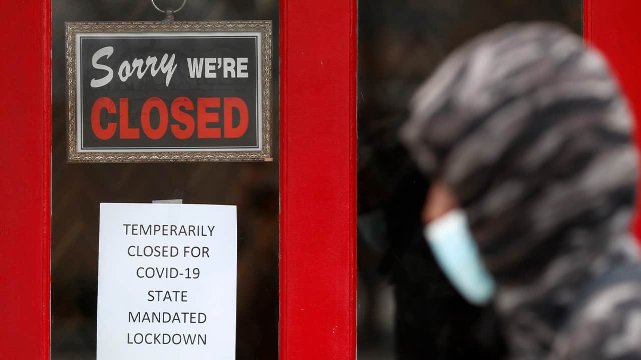 Photo of a man walking past a closed store
