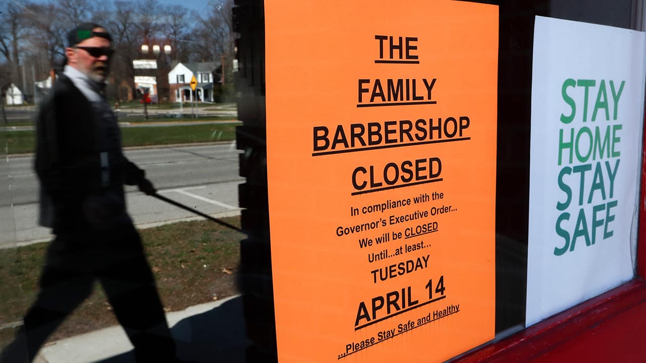 Photo of a man walking by a closed sign