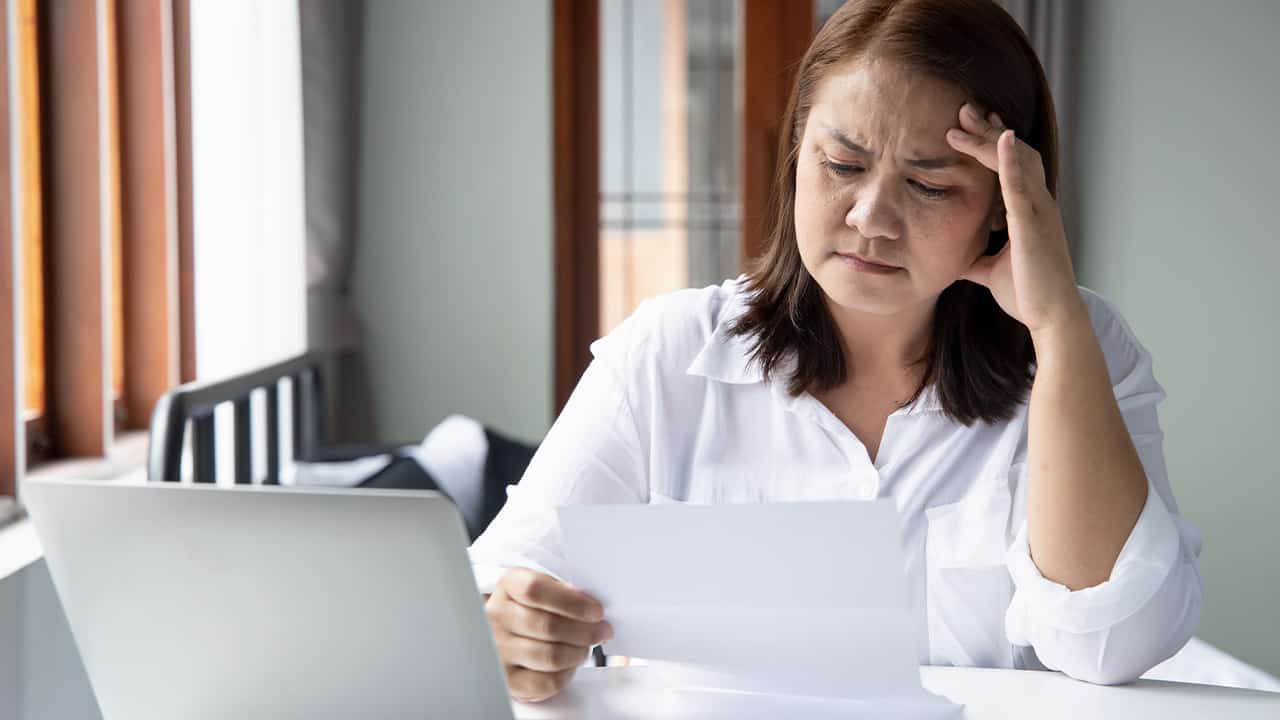 Photo of a woman contemplating how to pay her bills