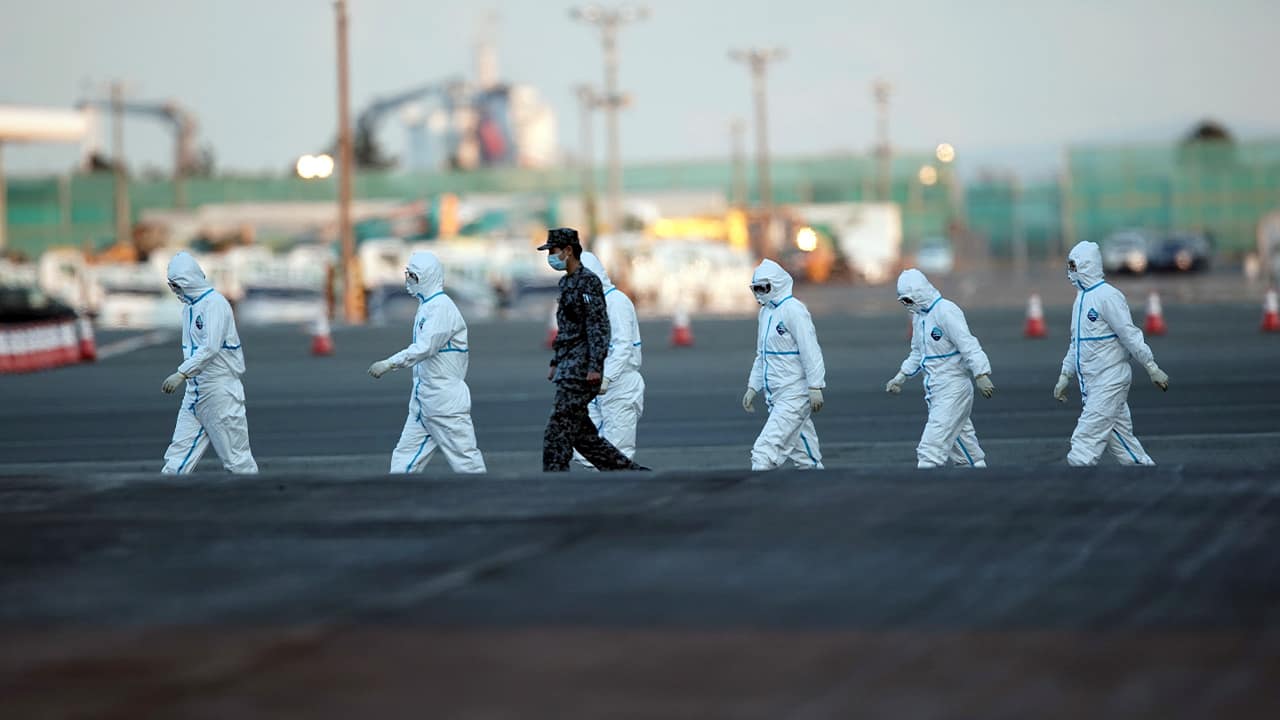 Photo of officials in protective suits 