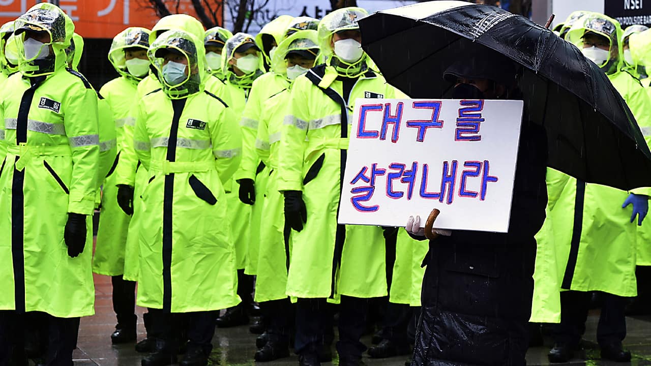Photo of protester holding a sign to denounce the government's response to the coronavirus 
