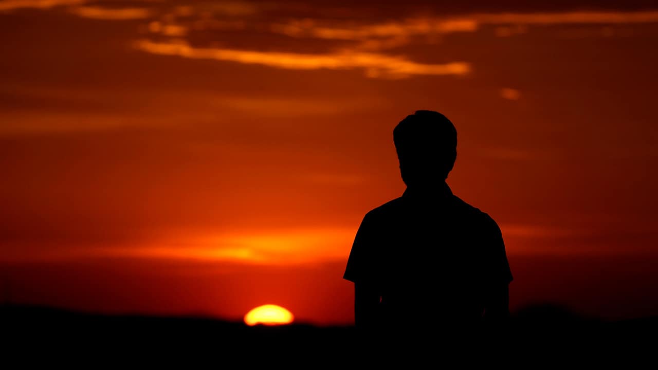 Photo of a man watching a sunset