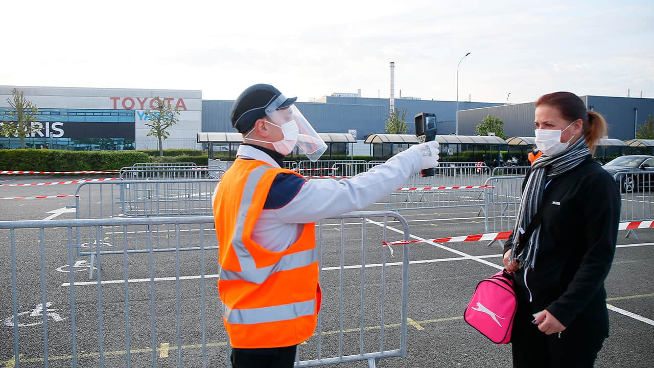 Photo of a man taking a woman's temperature