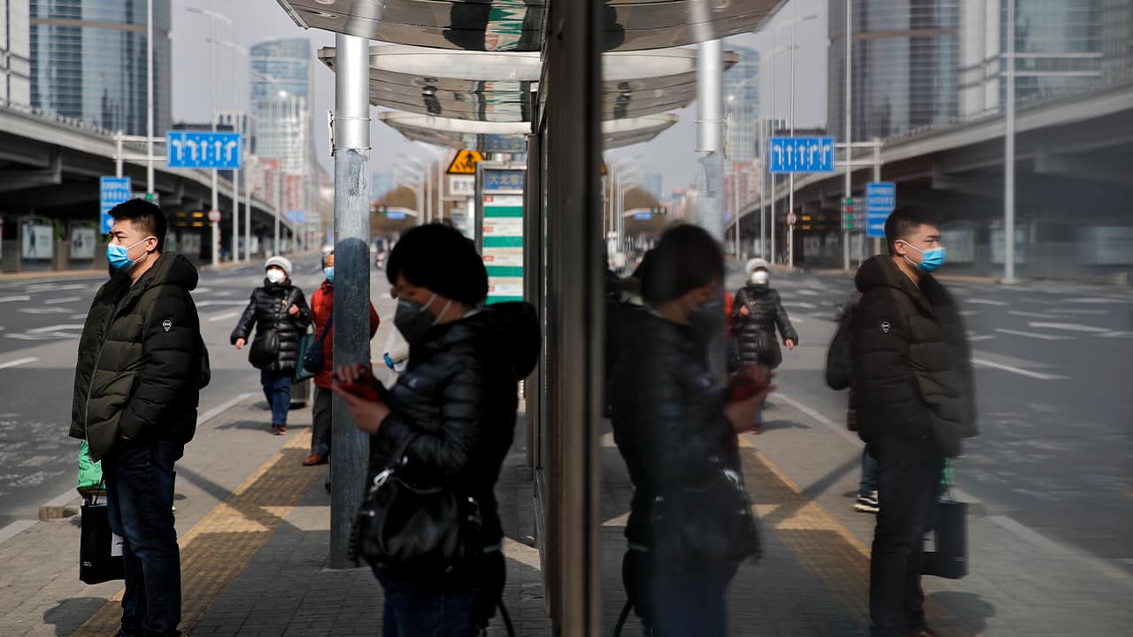 Photo of people wearing masks at a bus stop in Beijing 