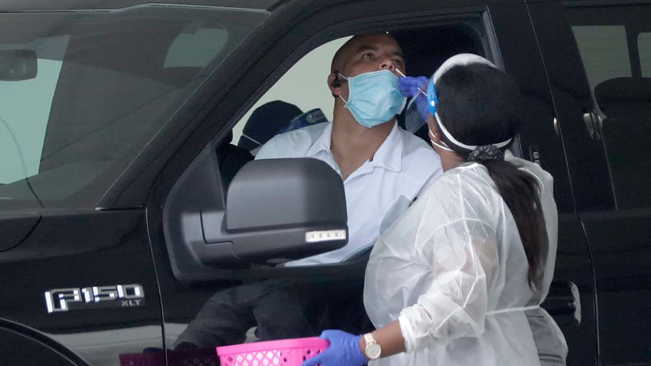 Image of a mobile COVID-19 test being given to a man in a car