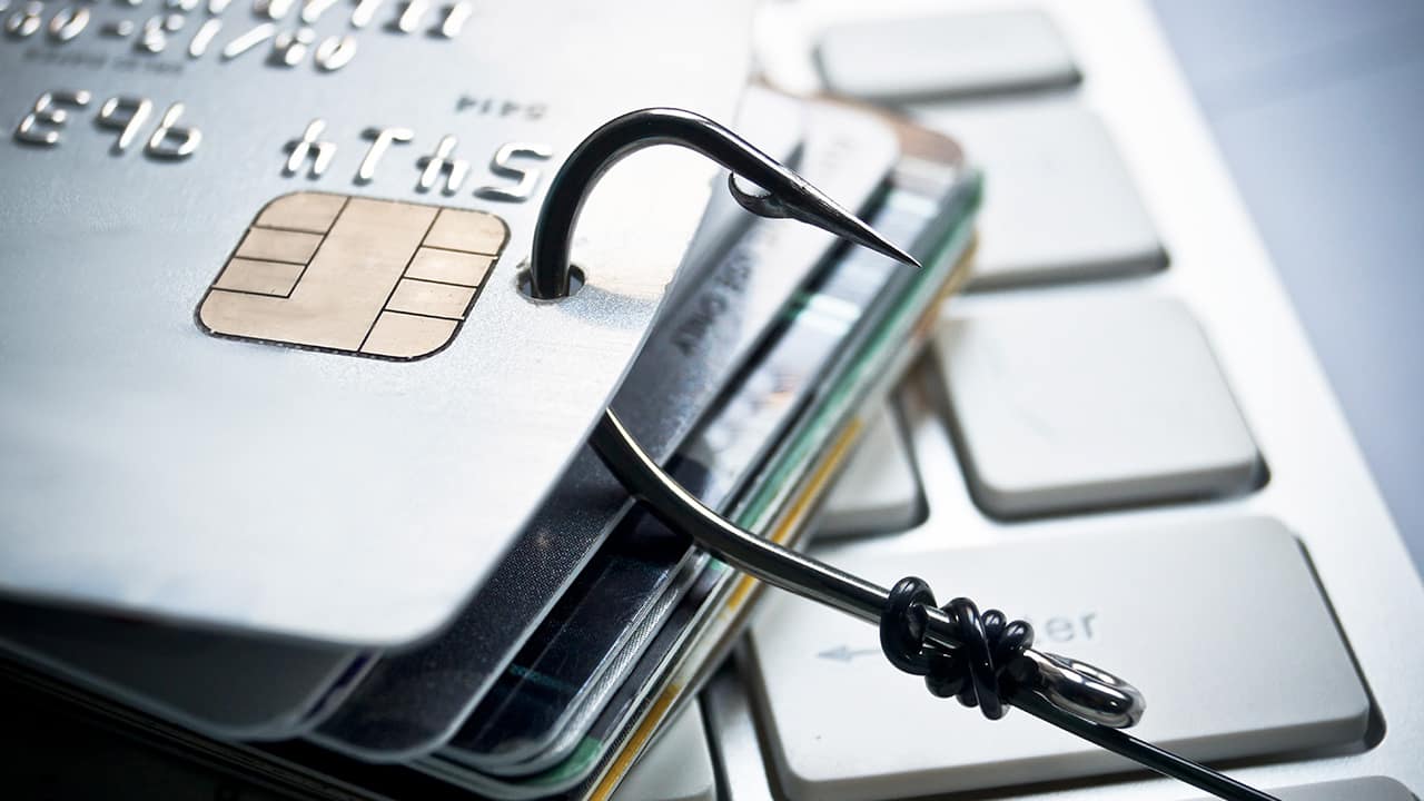 Photo illustration of a fishing hook snagging credit cards symbolizing theft and credit card fraud