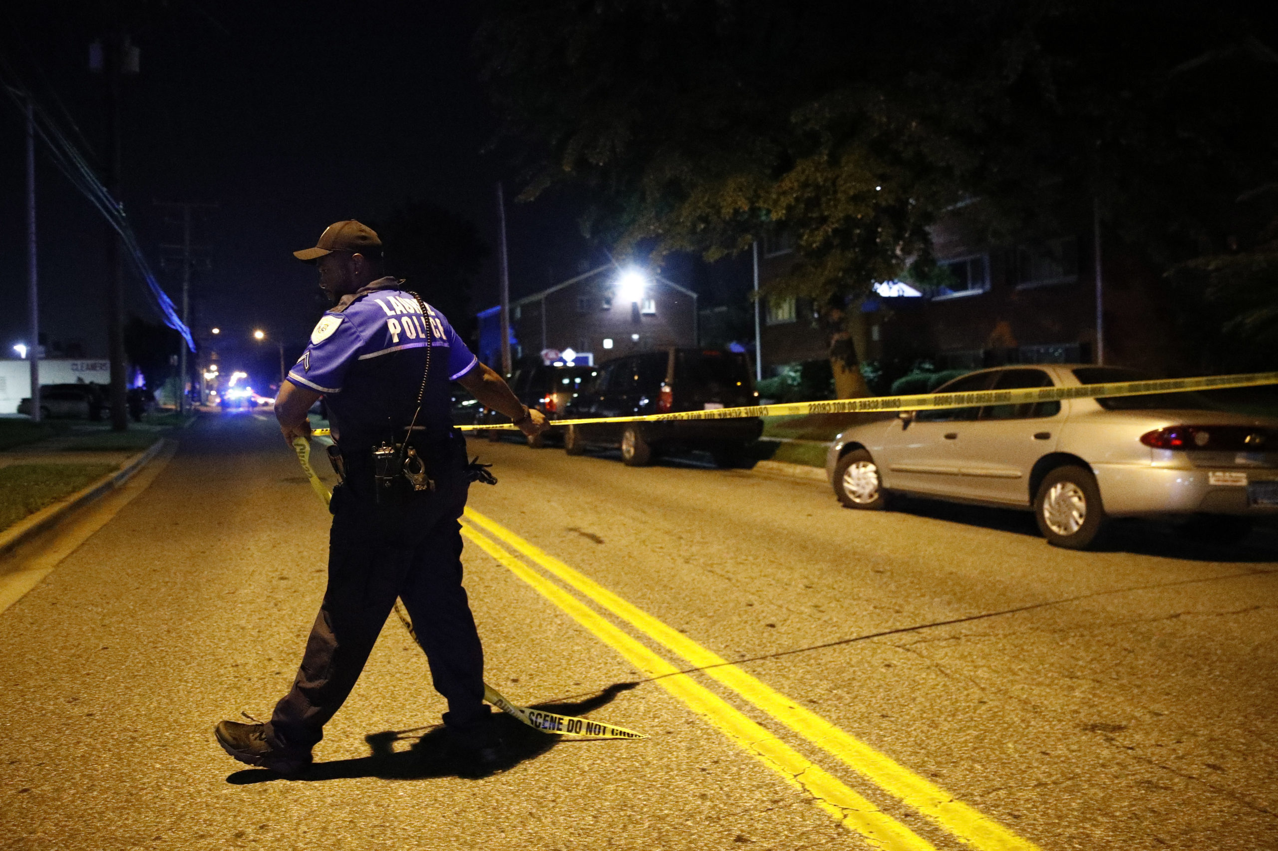 Photo of a police spreading crime tape