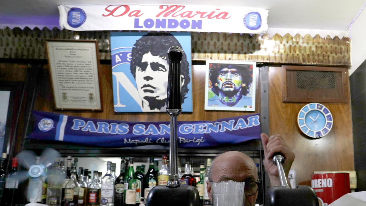 Photo of a bar tender preparing an espresso coffee inside the Bar Nilo where a makeshift shrine of soccer legend and former Napoli player Diego Armando Maradona is displayed