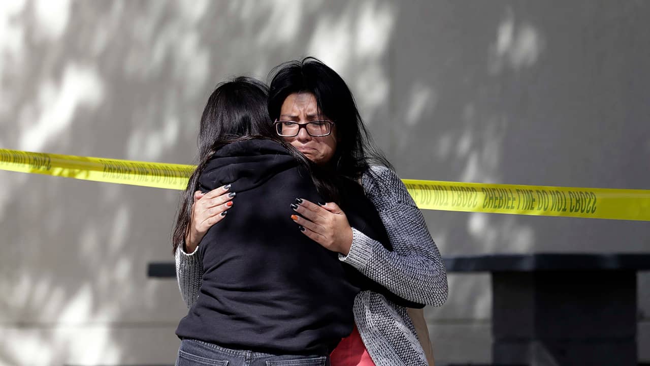 Photo of mourners embracing outside the Thousand Oaks Teen Center