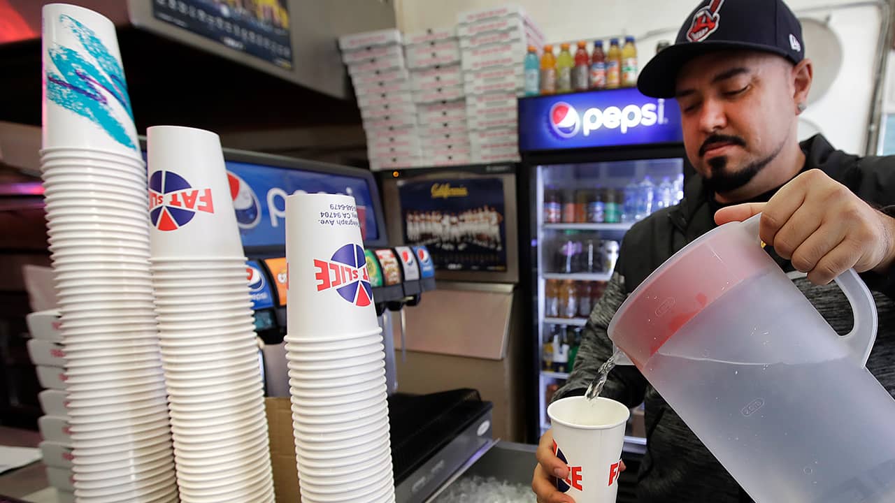 Photo of Gustavo Munoz filling a cup with water
