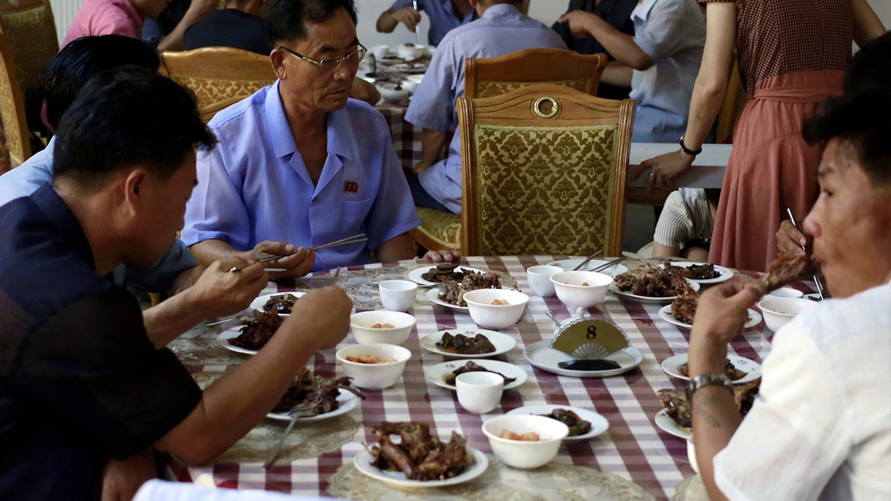Photo of men in North Korea eating dishes made with dog meat