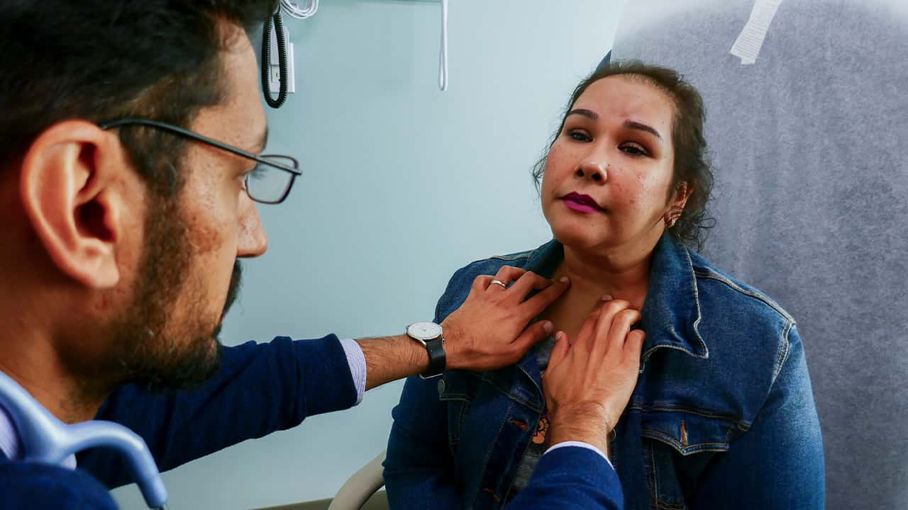 Photo of Dr. Moazzum Bajwa examining a patient's neck 