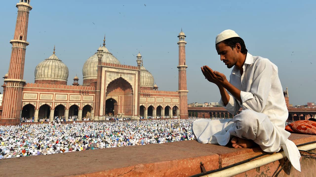 A Muslim offers prayers outside of a mosque.