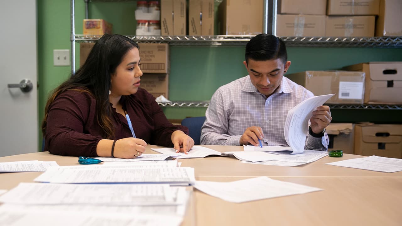 Photo of 2 people filling out detainer forms during a housing clinic