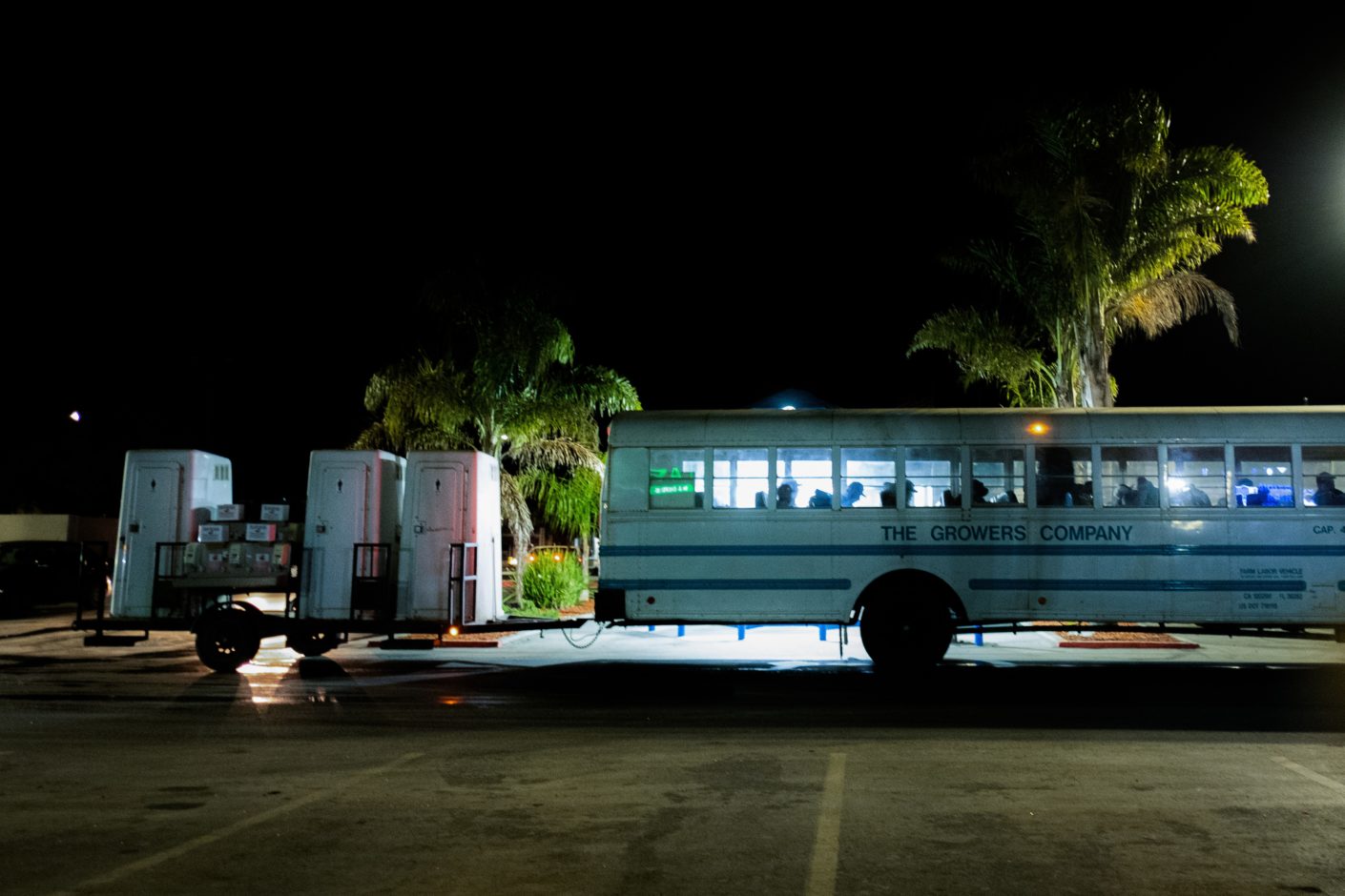 photo of farmworkers boarding bus at night