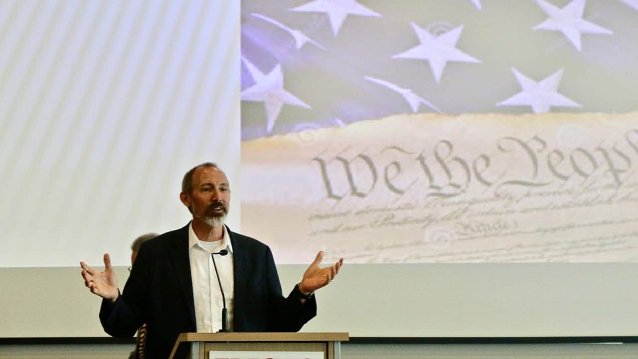 Photo of Andrew Fiala with an image of the U.S. Constitution in the background