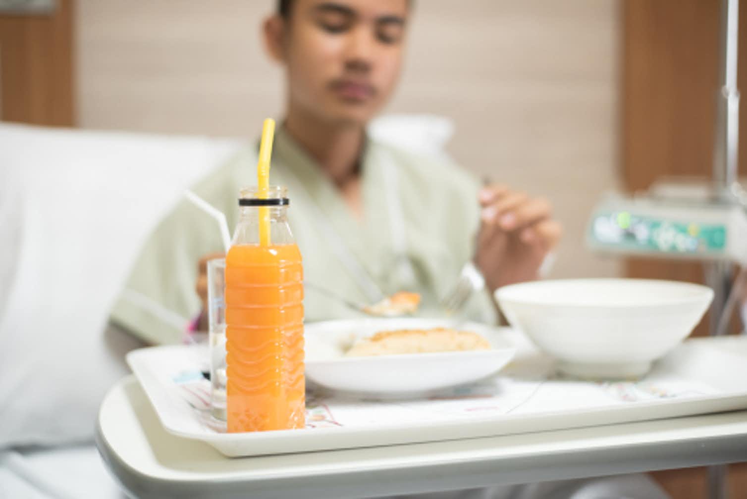 Photo of a man eating in a hospital bed 