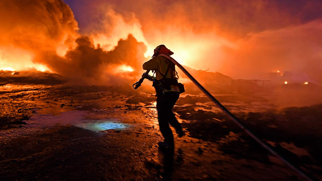 Photo of firefighter dragging a hose 