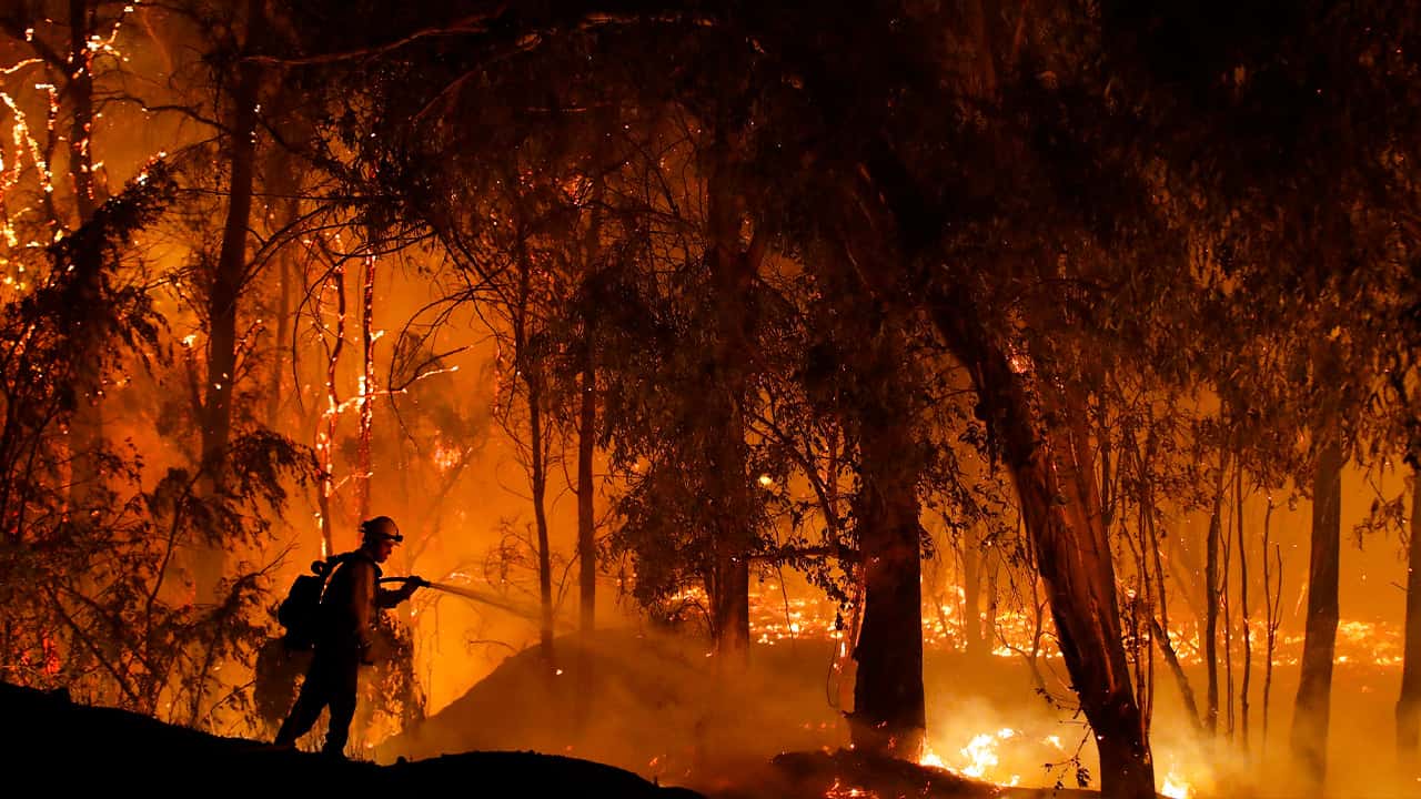 Photo of firefighter battling a wildfire in California