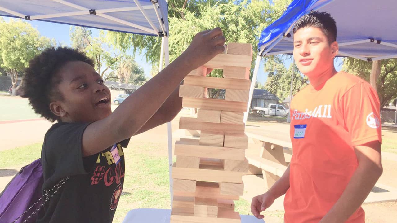 Photo of two teens playing giant Jenga in a Fresno park