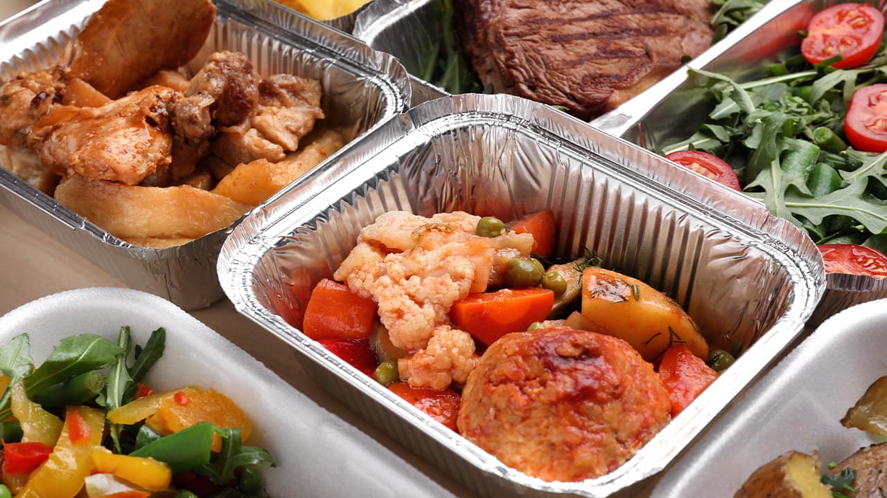 Photo of different types of food in aluminum catering containers