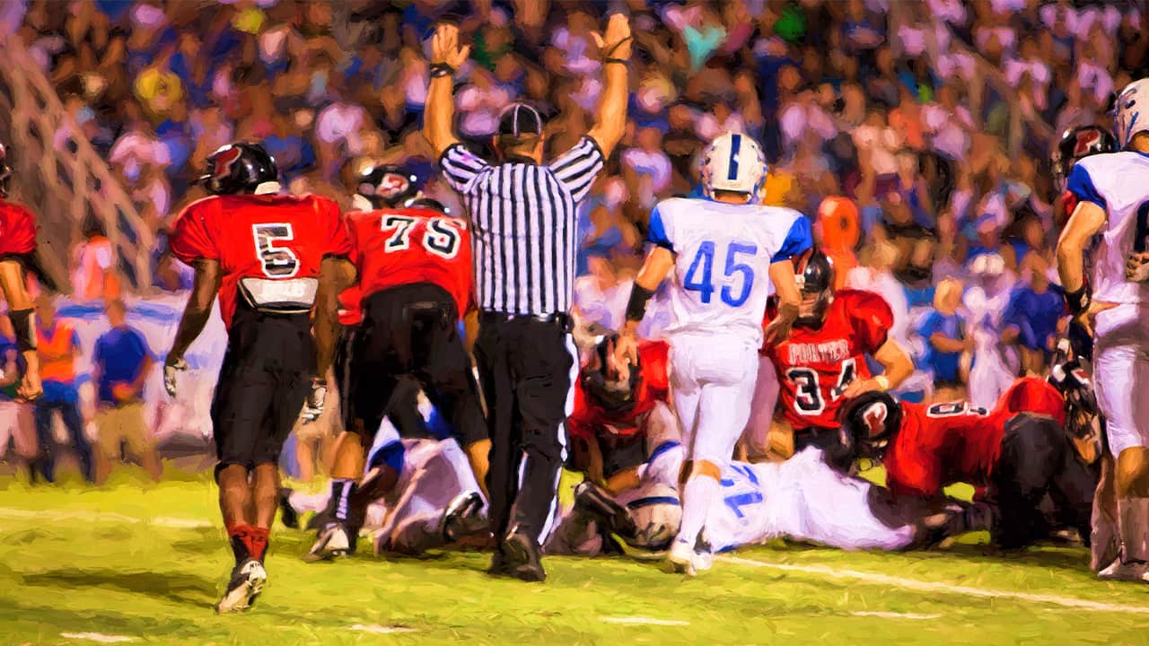 Photo of a referee signaling a touchdown in a high school football game