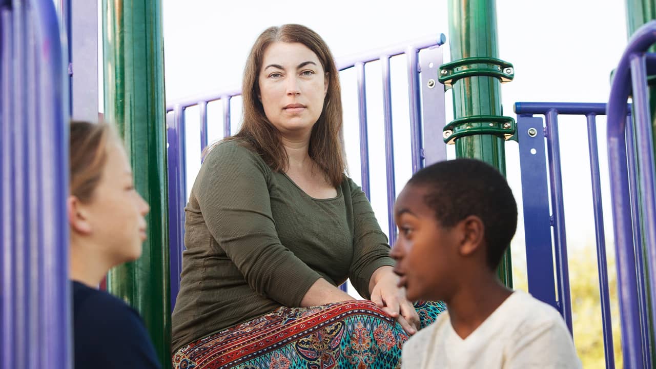 Photo of 2 kids and a mother on a playground