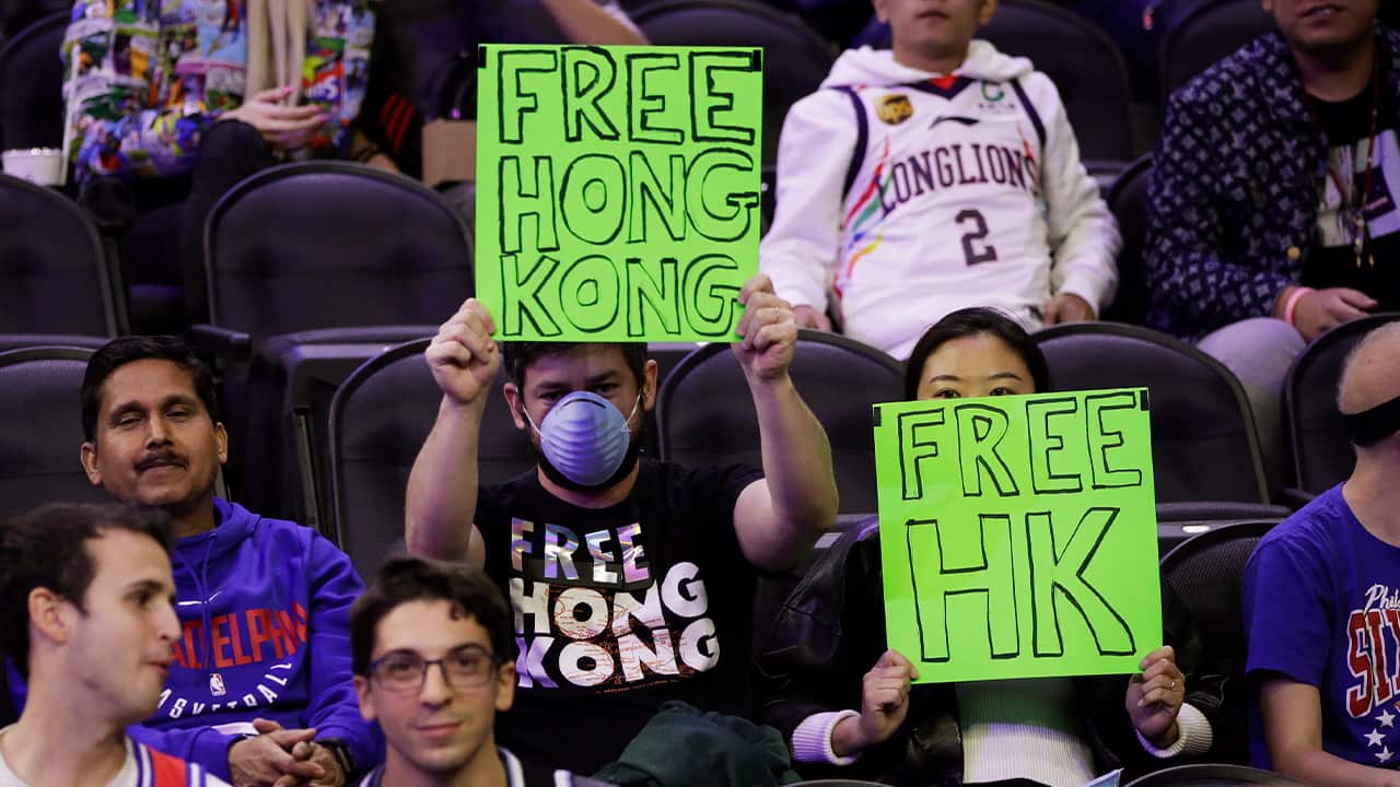 Photo of fans holding signs ahead of an NBA exhibition game 