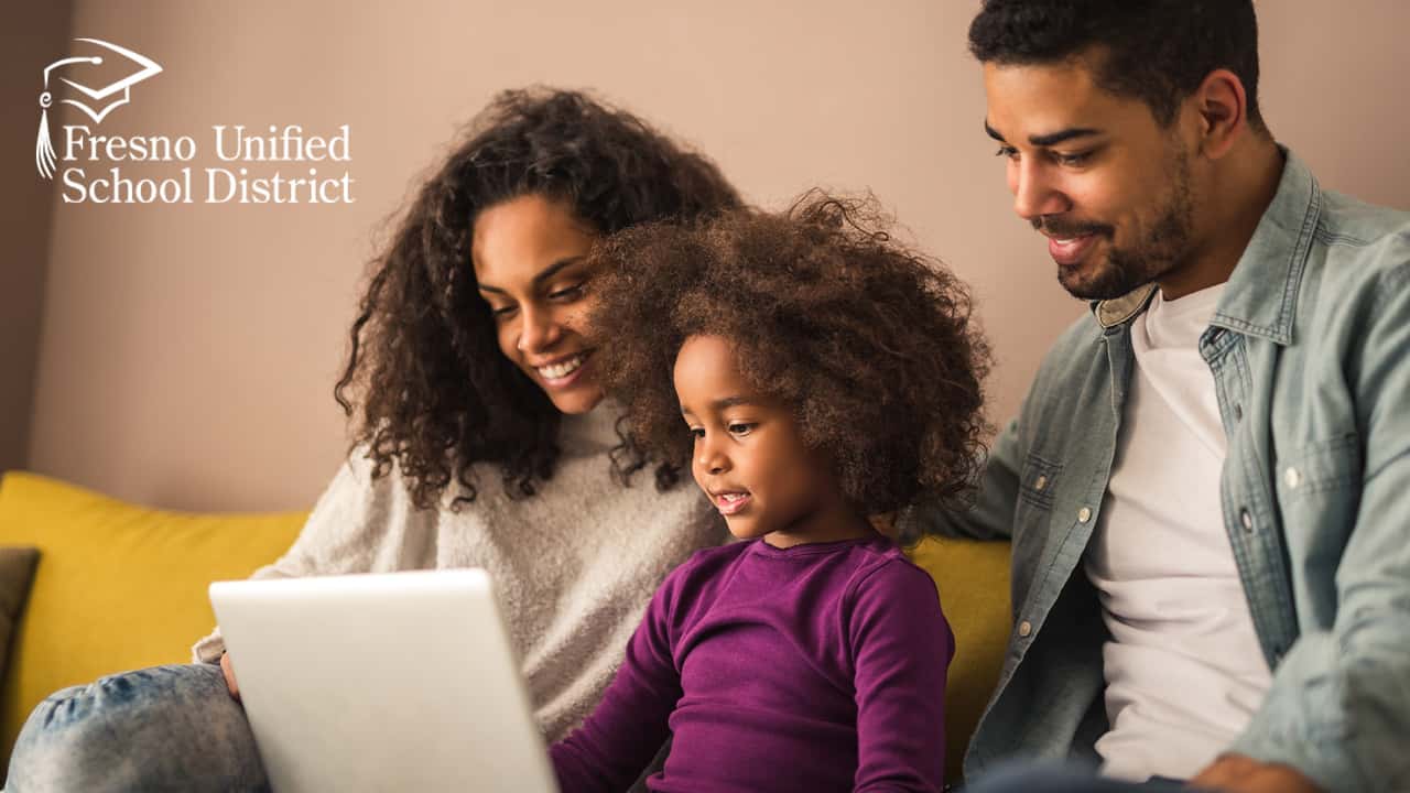 Image of Black parents checking out what their daughter is learning on her laptop