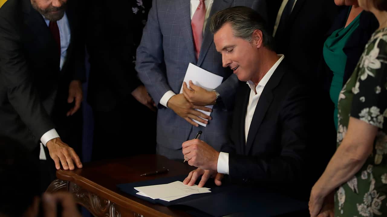 Photo of Gavin Newsom signing AB1482