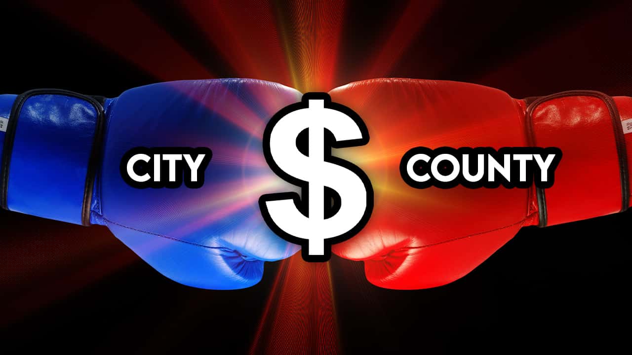 Image of boxing gloves colliding and radiating a dollar sign
