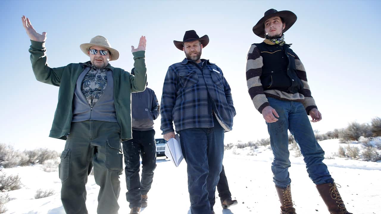 Photo of Burns resident Steve Atkins, left, talking with Ammon Bundy, center, one of the sons of Nevada rancher Cliven Bundy