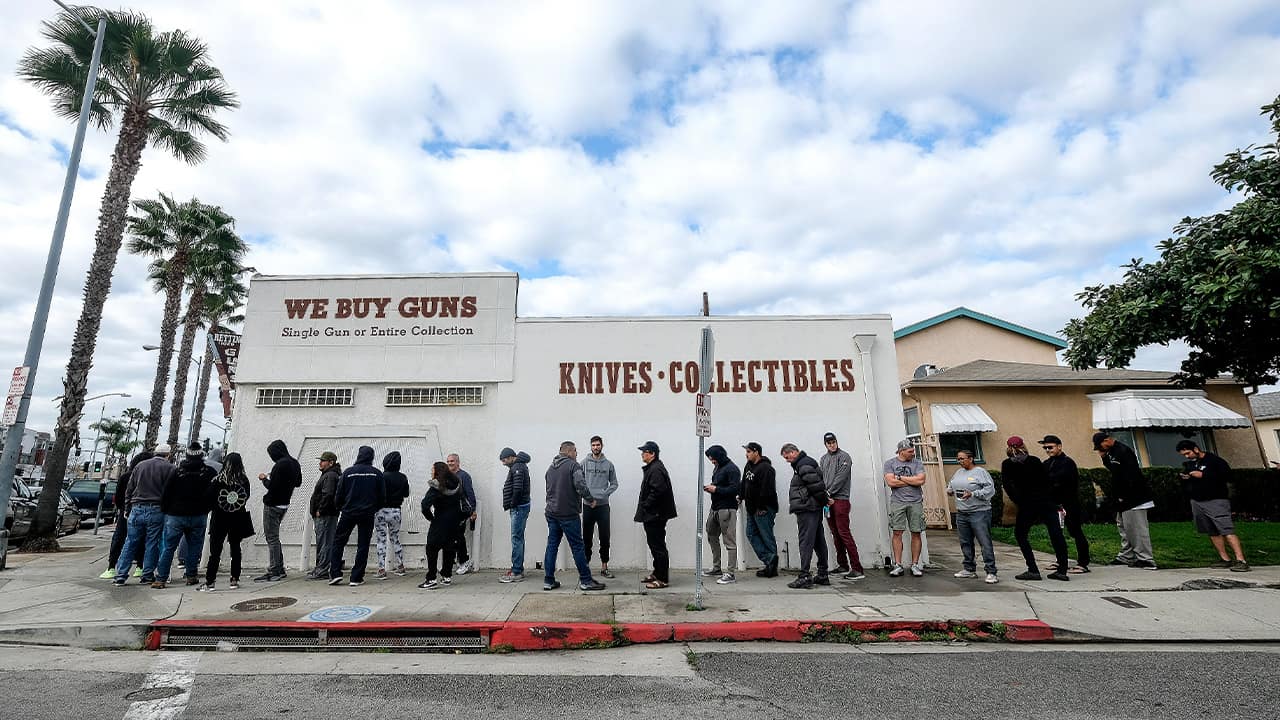 Photo of people lining up outside of a gun store