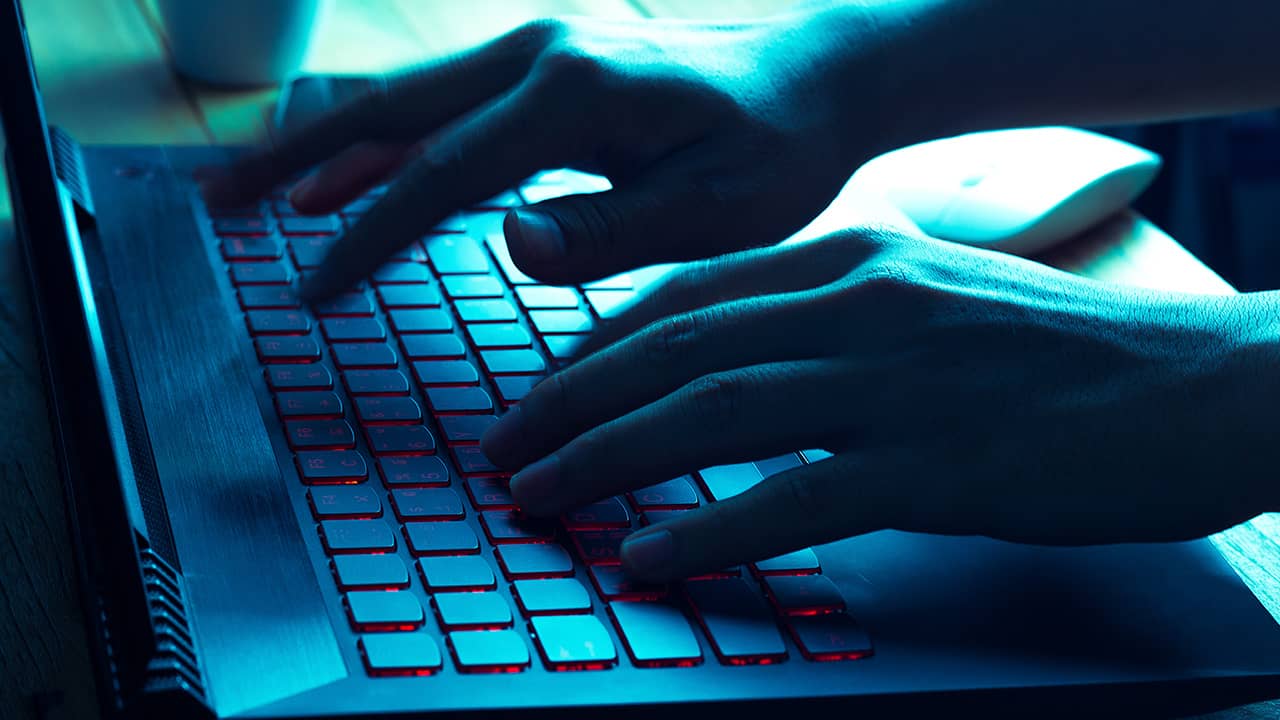 Photo of a hacker typing on a laptop