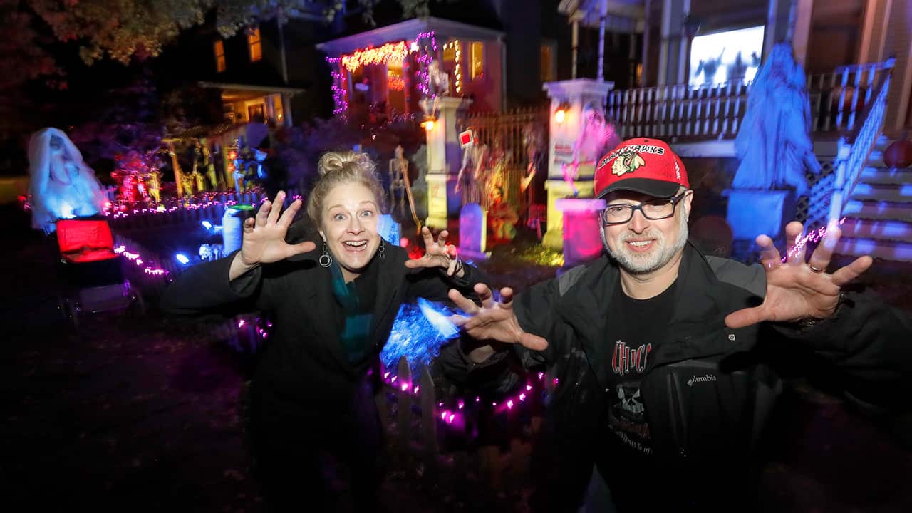 Photo of Beth LeFauve and Nelson Gonzalez posing in front of their decorated homes