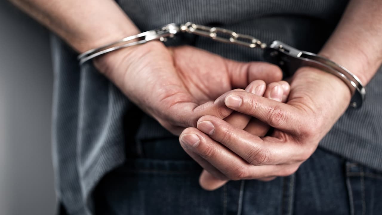 Photo of man in handcuffs as seen from behind
