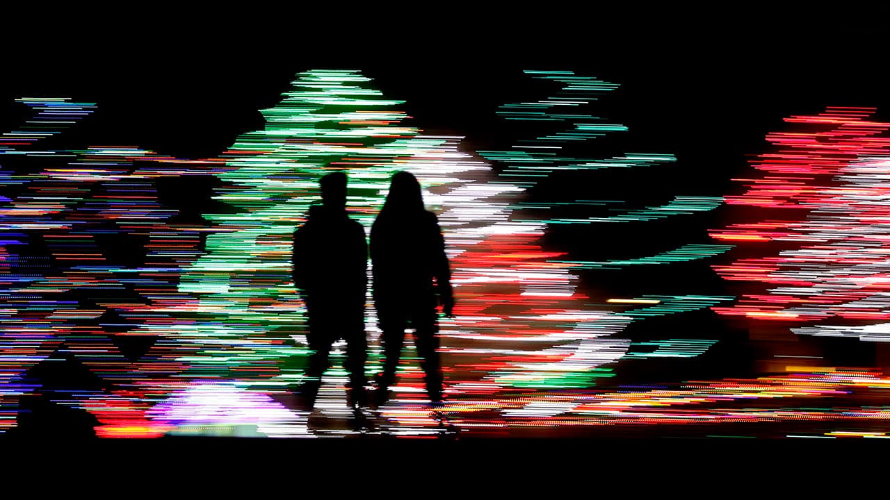 Photo of people against a Christmas lights display